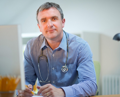 General Practitioner sitting at desk filling out psychology referral