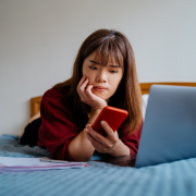 Teenager on bed experiencing cyberbullying