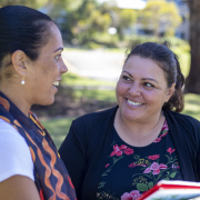 Woman talking to another woman in a sunny park outside