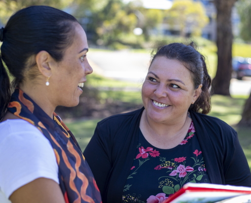 Woman talking to another woman in a sunny park outside