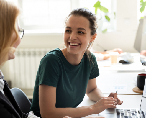 Two women at a desk creating workplace mental health policy