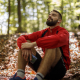 Portrait of relaxed young man with bluetooth headphones in forest