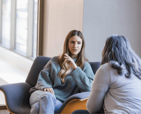 Woman in wooly jumper talking to mental health psychologist